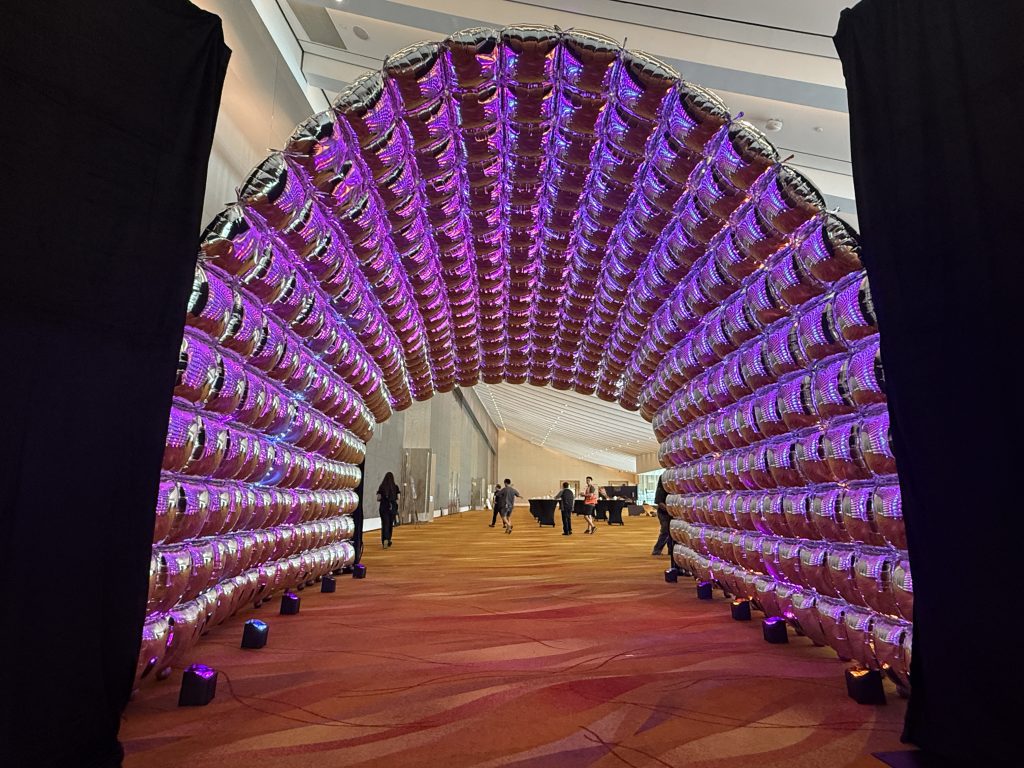 Chrome foil balloon tunnel arch with purple LED uplighting
