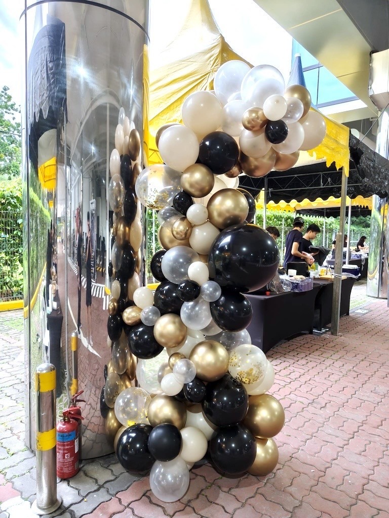 Black and gold organic balloon garland and column for corporate event in Singapore