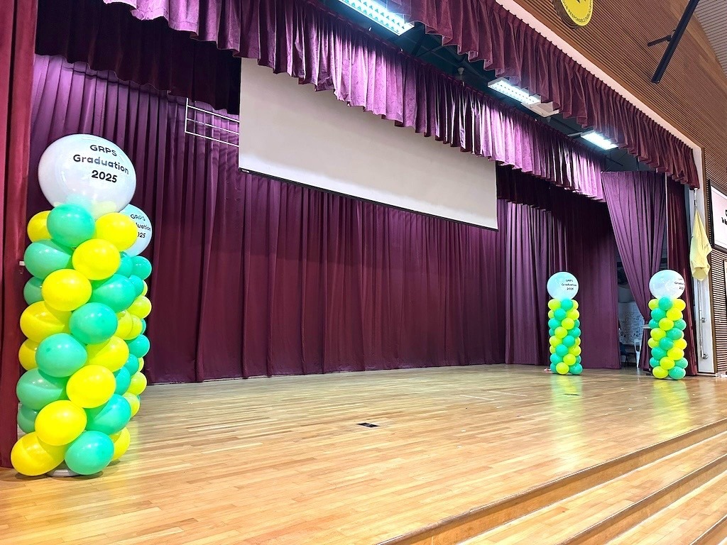 Graduation balloon columns framing a school stage balloon decoration Singapore