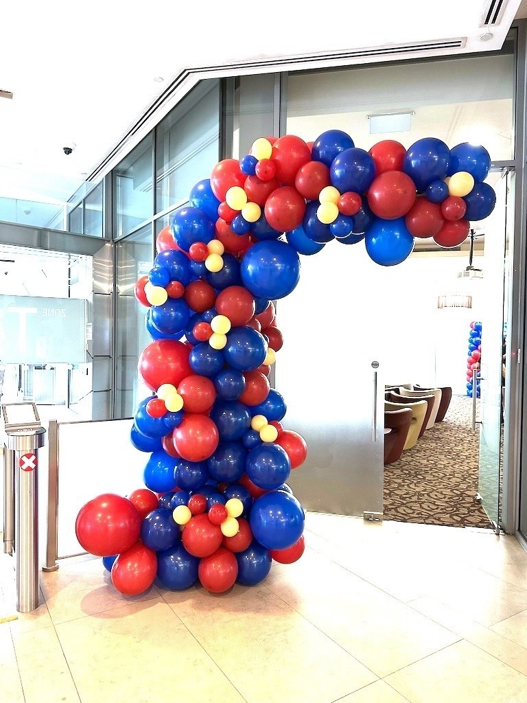 Organic red, blue and yellow balloon arch at a corporate entrance event decorations Singapore