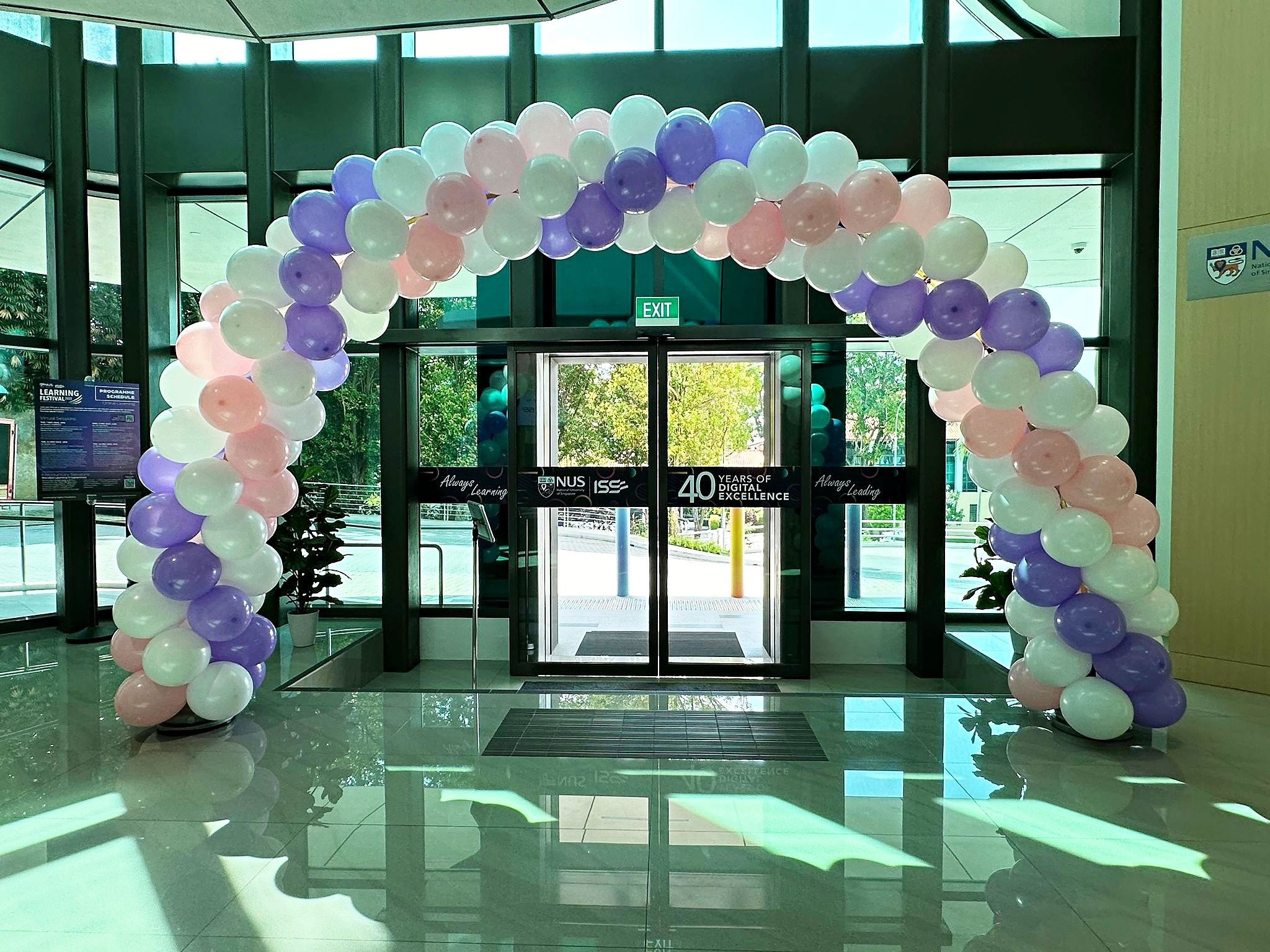 Pastel spiral balloon arch inside a glass entrance
