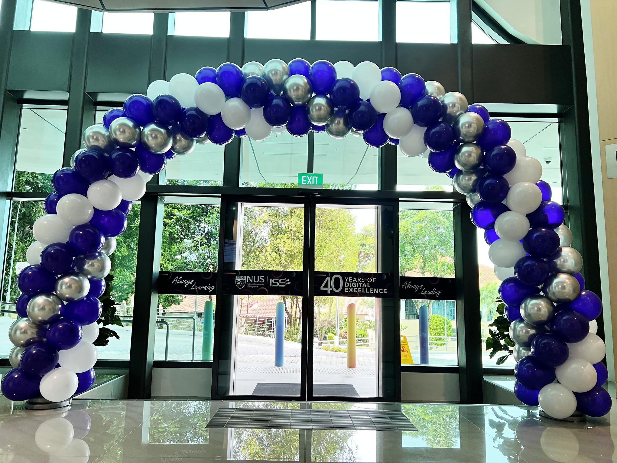 Purple white and silver spiral balloon arch at an indoor entrance