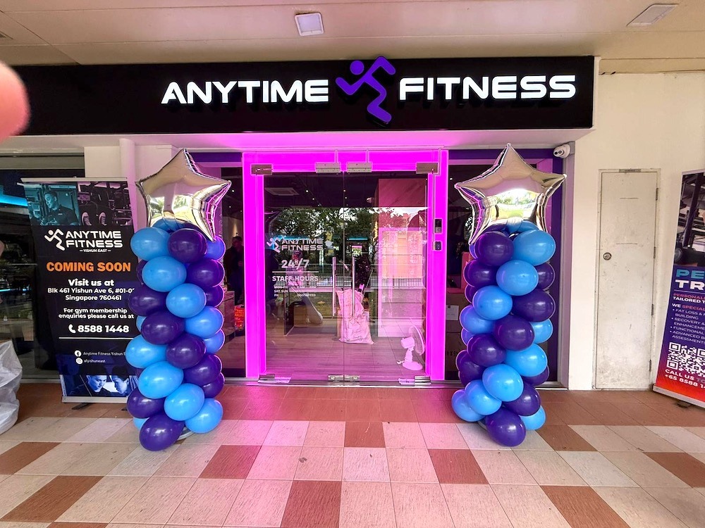 Purple and blue balloon pillars framing a fitness studio entrance