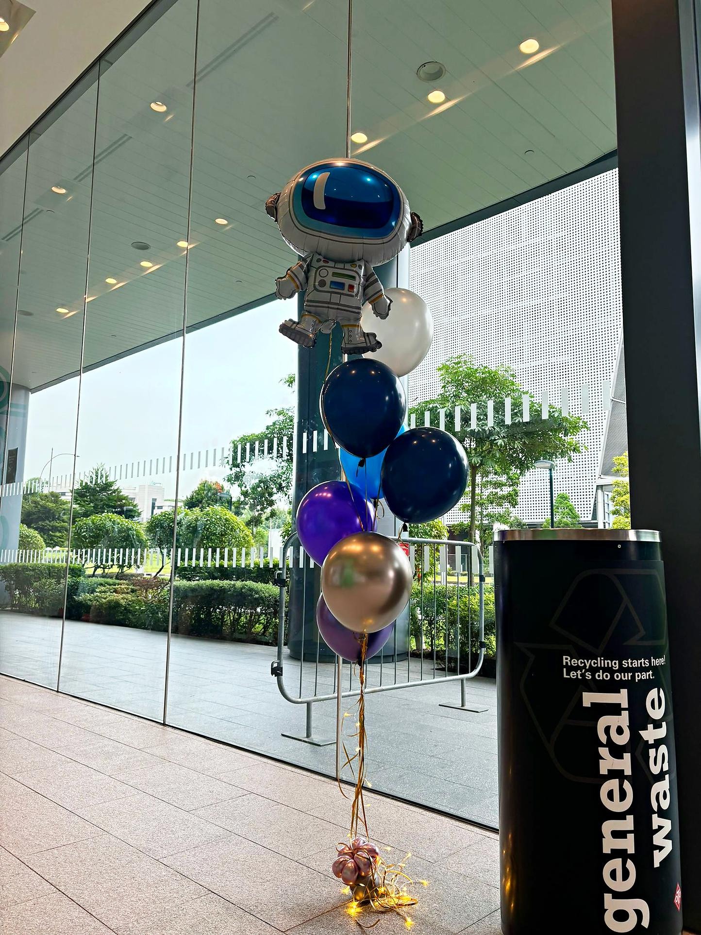 Astronaut foil balloon above a blue silver and purple bouquet