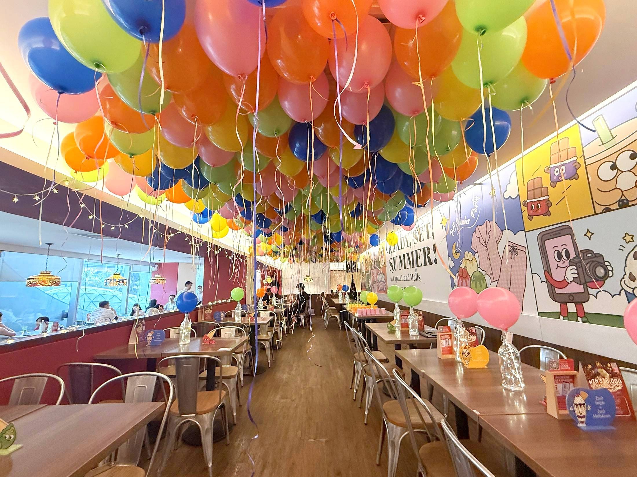 Multicoloured helium balloons decorating a restaurant ceiling