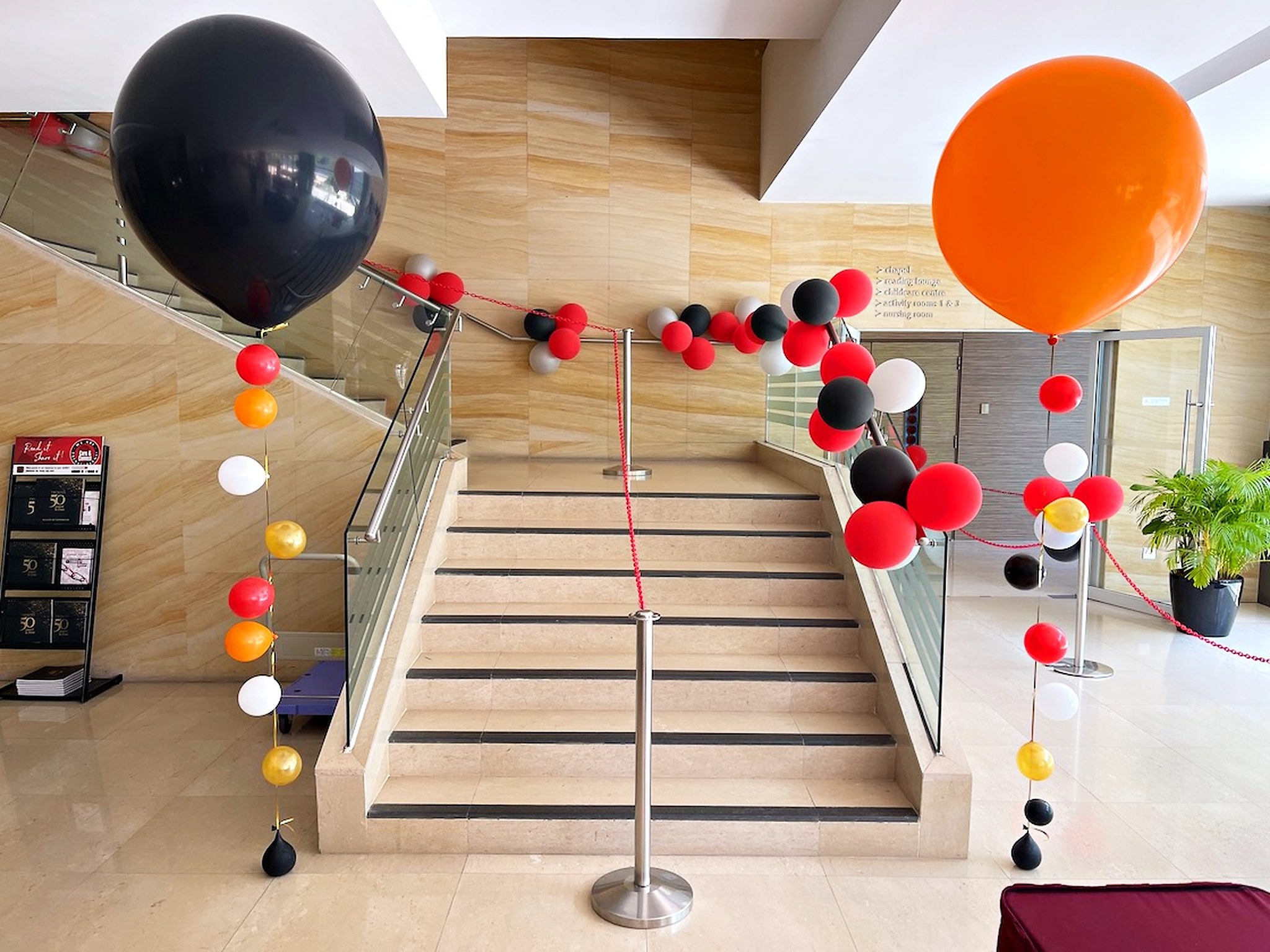Black and orange helium balloon displays framing a staircase
