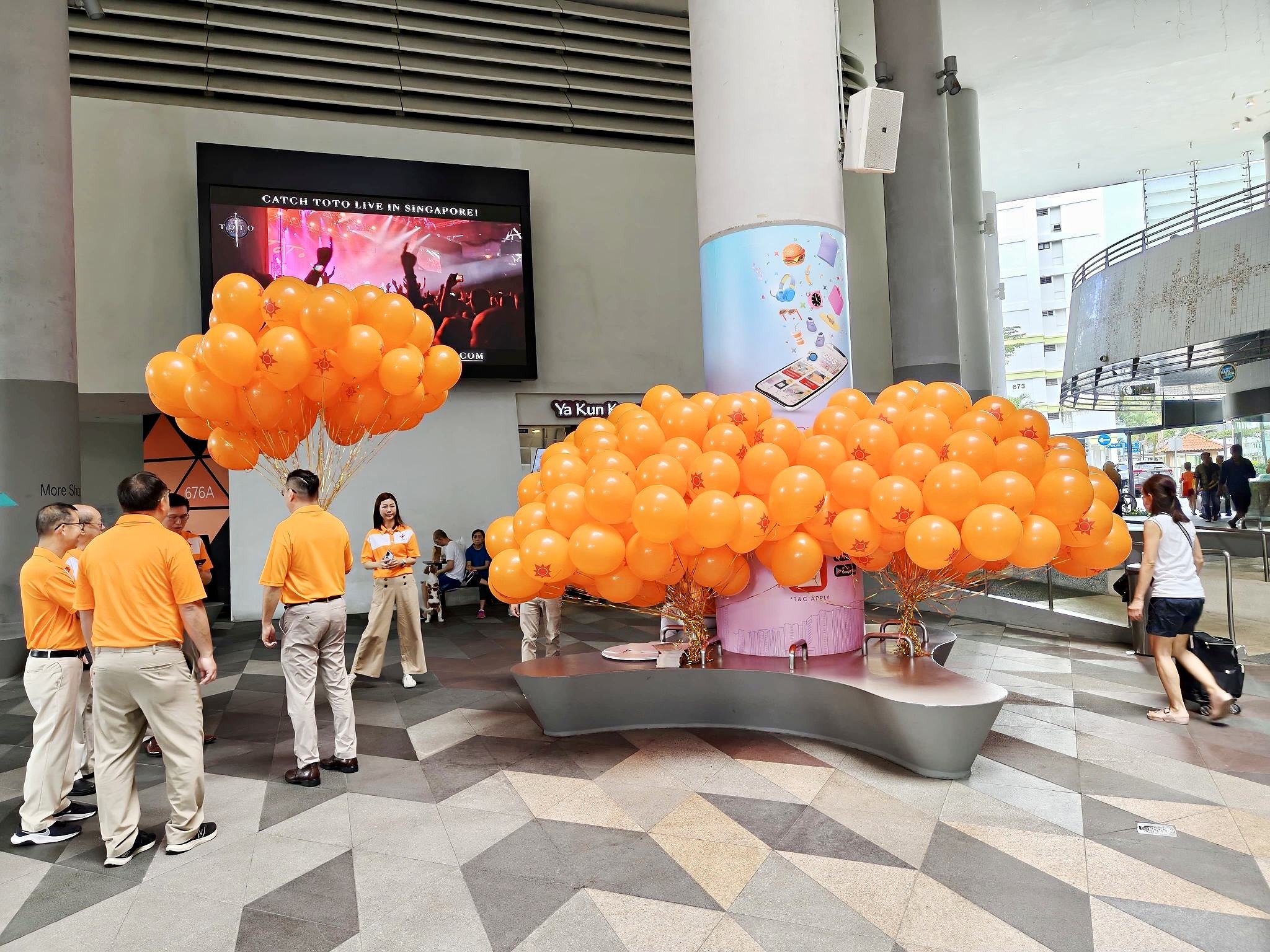 Orange helium balloon bunches at a concert arrival area