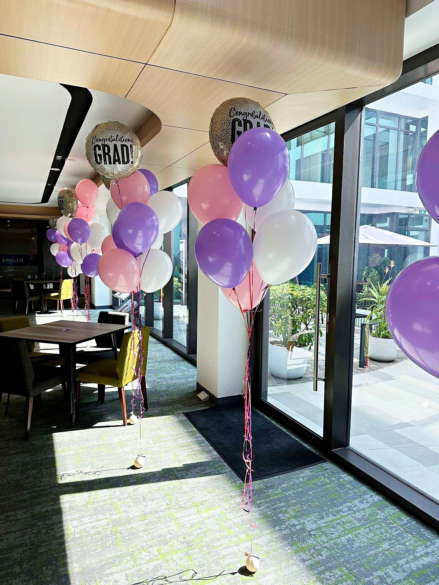 Pastel helium balloon bouquets with graduation foil balloons