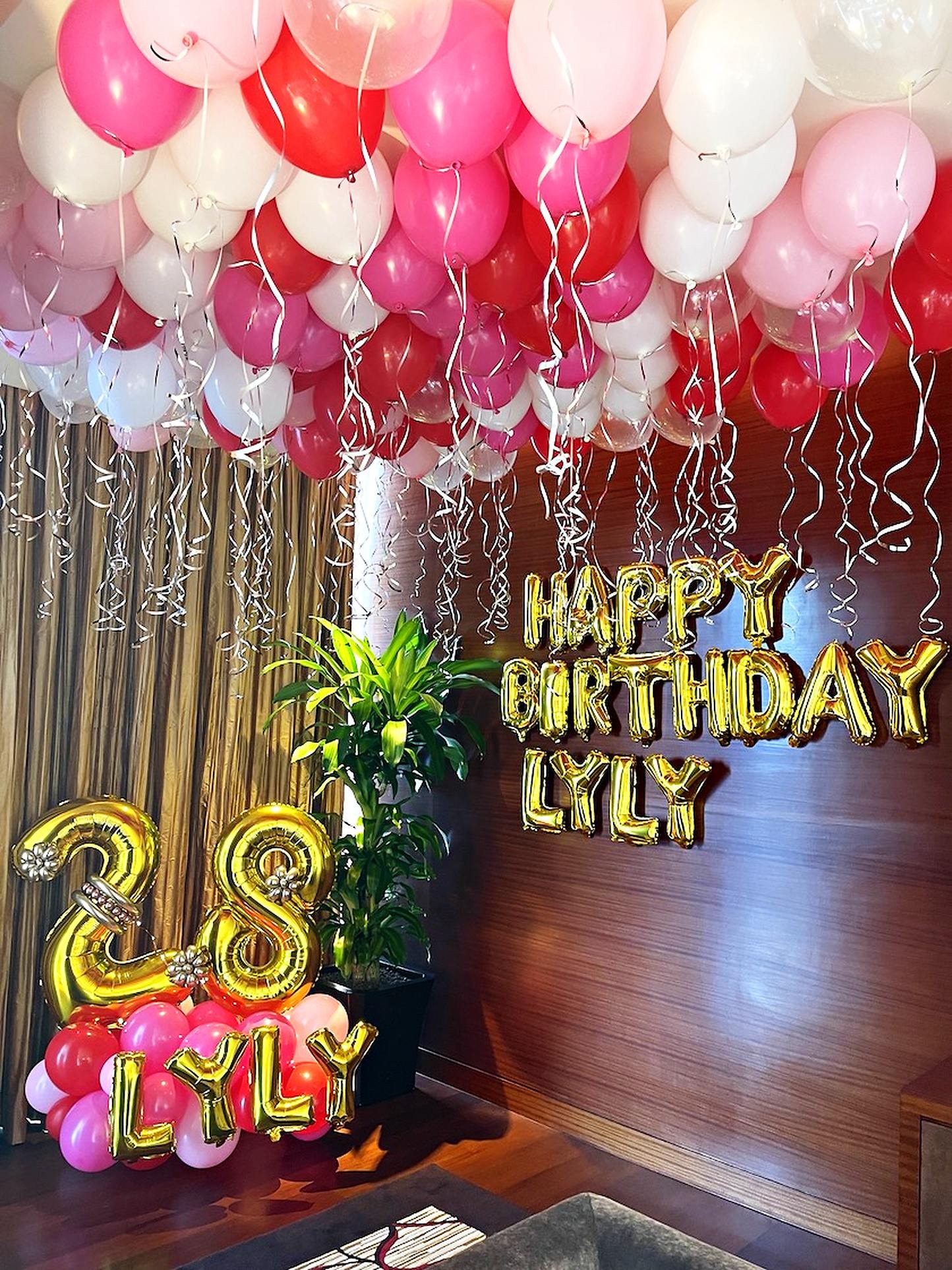 Pink white and red ceiling balloons with gold birthday lettering