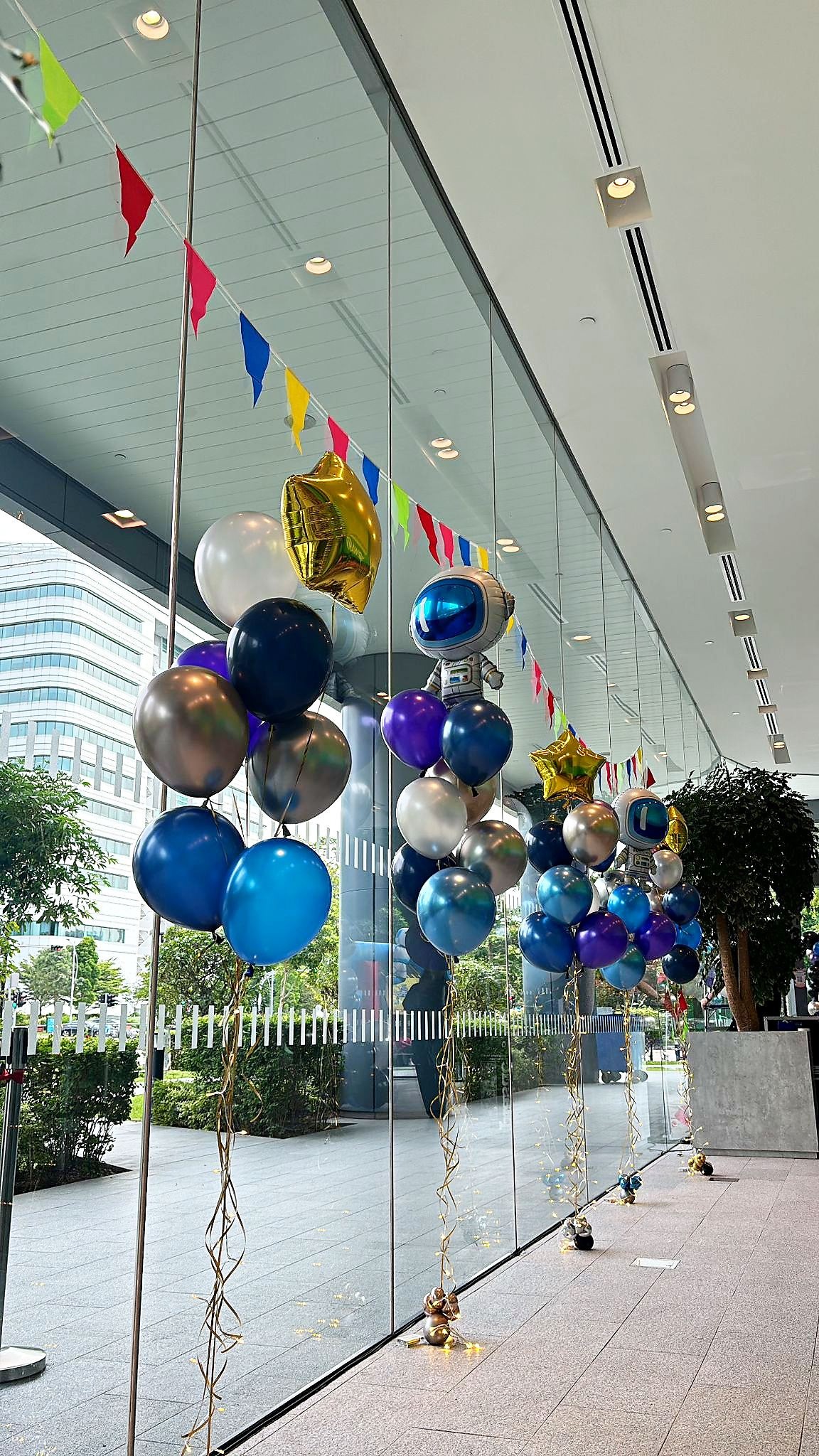 Space themed helium balloon bouquets lining a window