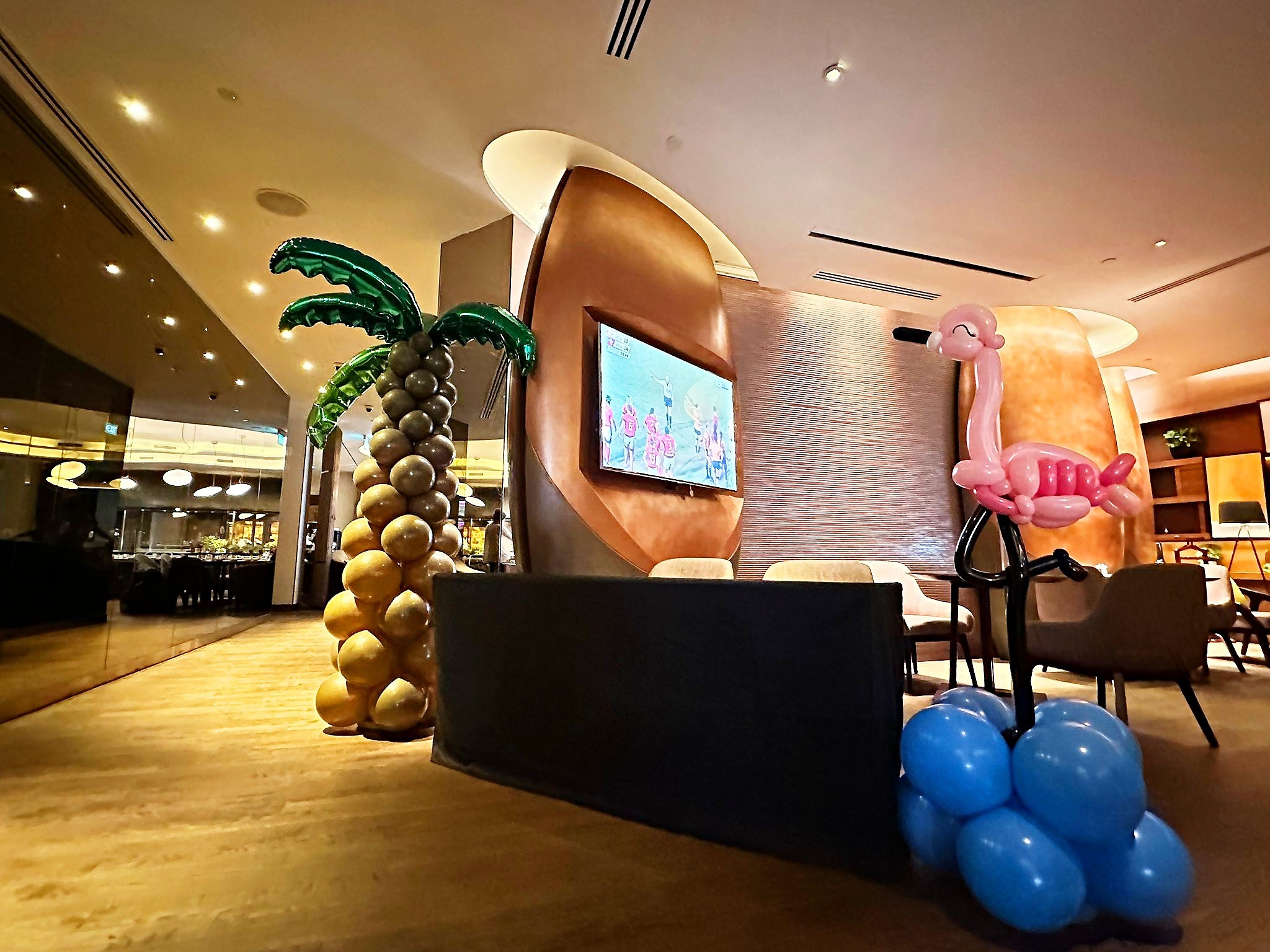 Tropical palm and flamingo balloon sculptures in an event room